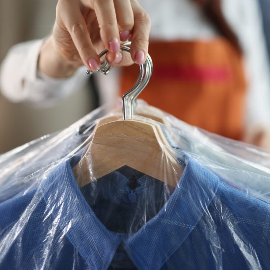 Close-up,Of,Worker,Giving,To,Client,Clean,Clothes,Hanging,On